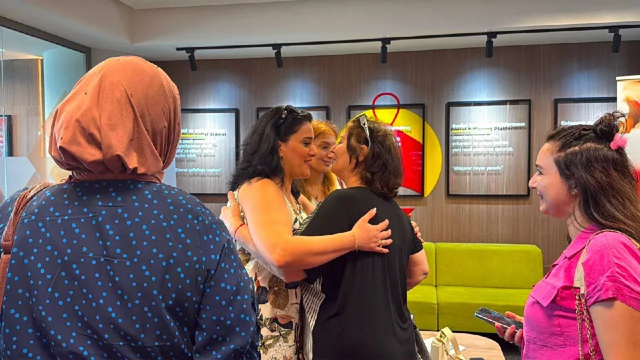 NexBirlik marka panosu önünde sohbet eden katılımcılar